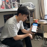 球探体育旧版用户小刘，年轻男性，在宿舍使用手机